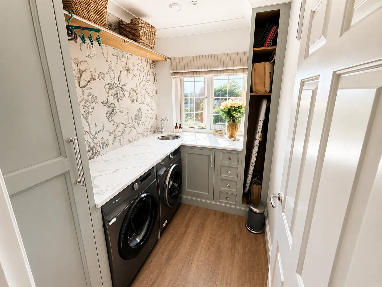 Separate laundry room with washer, dryer, sink and hanging rail