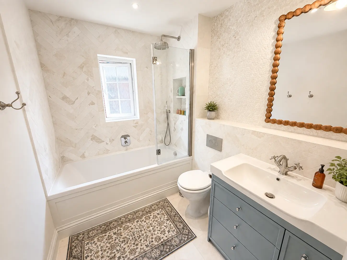 Family bathroom with a bath, overhead shower and herringbone stone tiling