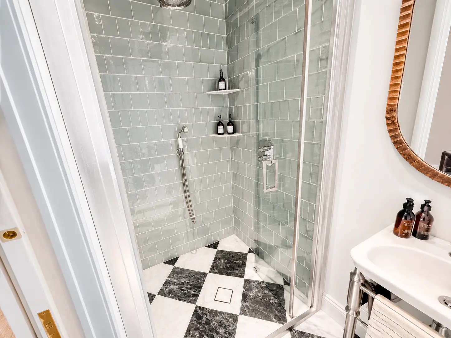 En-suite shower room with green tiling and a chequerboard marble floor